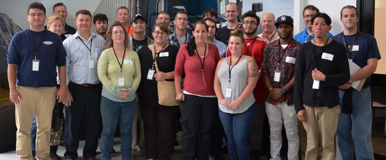 A group of people wearing lanyards pose for a photo.