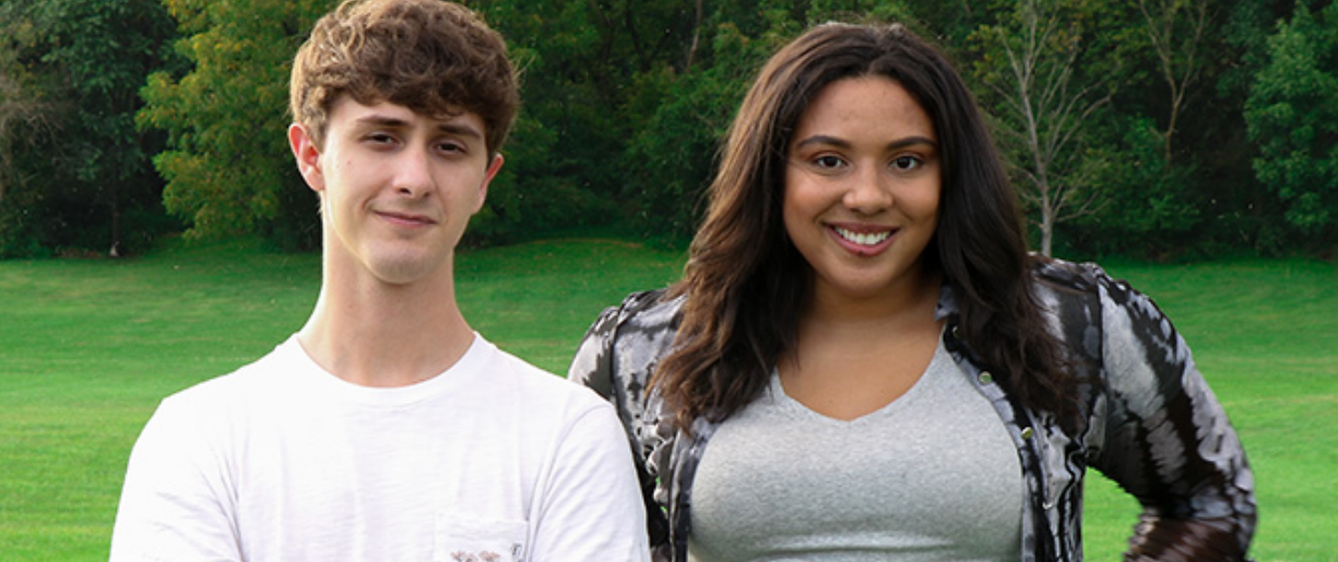 A young man and woman pose side by side.