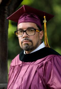 Jose Rivera in maroon graduation cap and gown