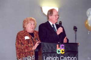 A woman and man stand at a podium that has the LCCC logo on it.