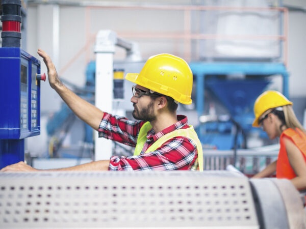 Workers in factory operating machines