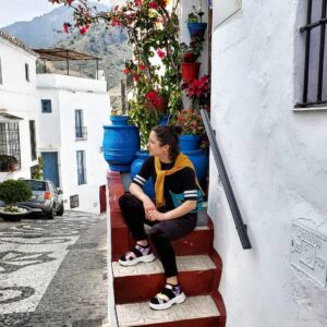 Sam Fruhwirth sits on steps outside a home in Spain.