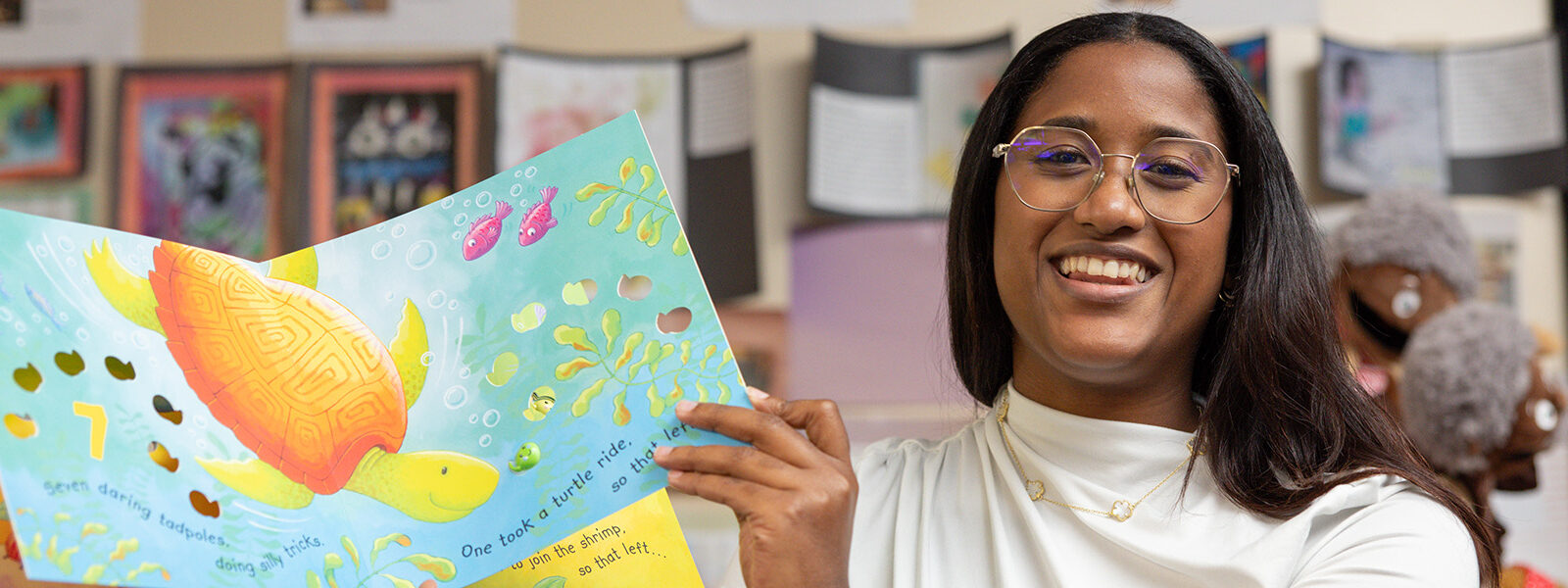 Student reading a children's book to a class