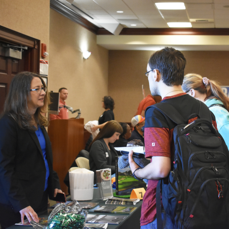 Image shows two students speaking with an employer at the Job Fair.